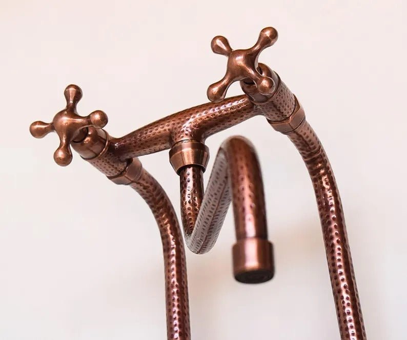 Handcrafted hammered copper kitchen faucet with dual cross handles and brass finish, combining durability and classic style.